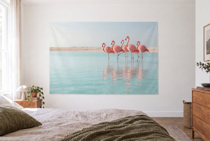 Wandtuch Flamingos in der Lagune im hellen Schlafzimmer gegenüber dem Bett, rechts eine Holzkommode – Rosa und Türkis
