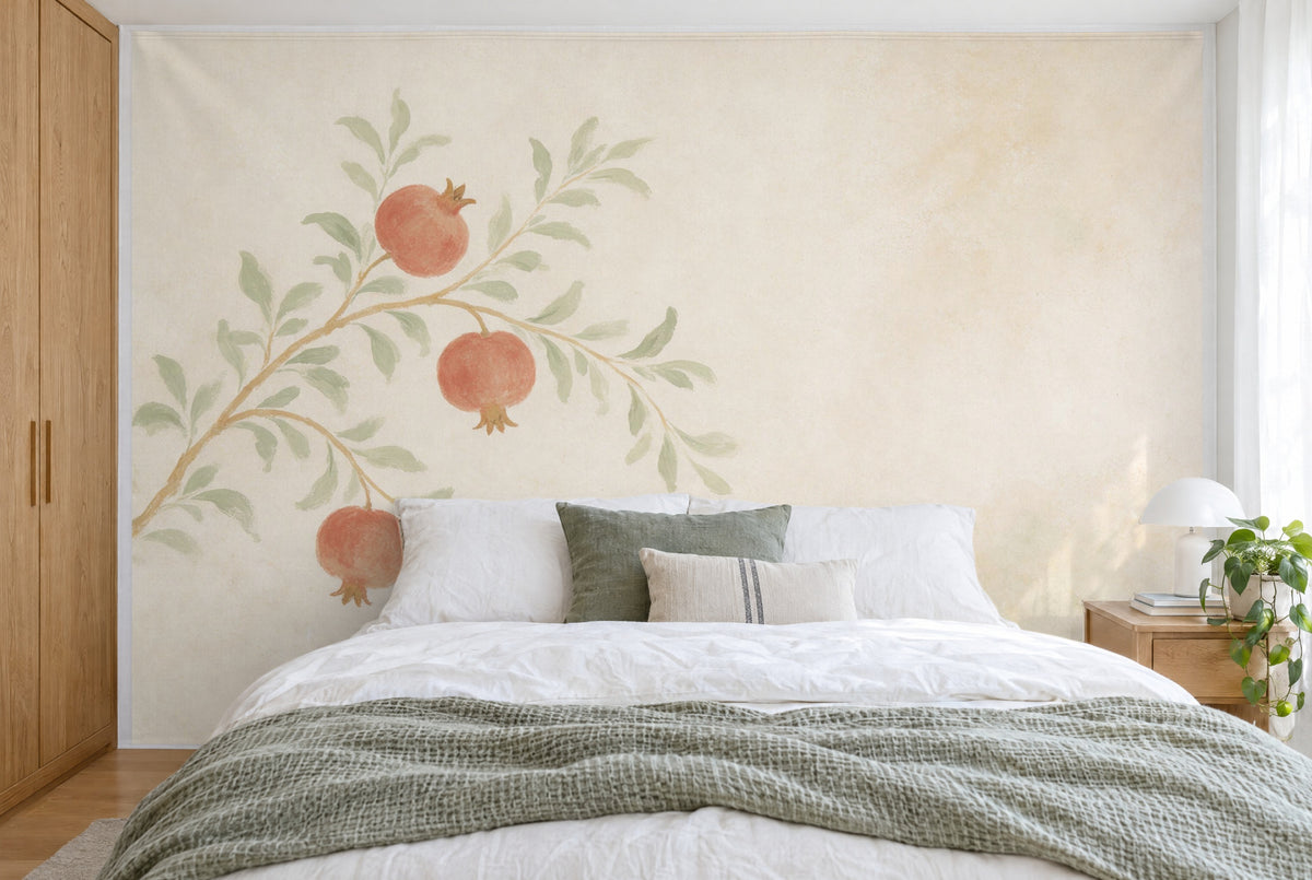 XXL printed fabric: pomegranate branch with three fruits at left on light lime plaster, filling the wall behind the bed