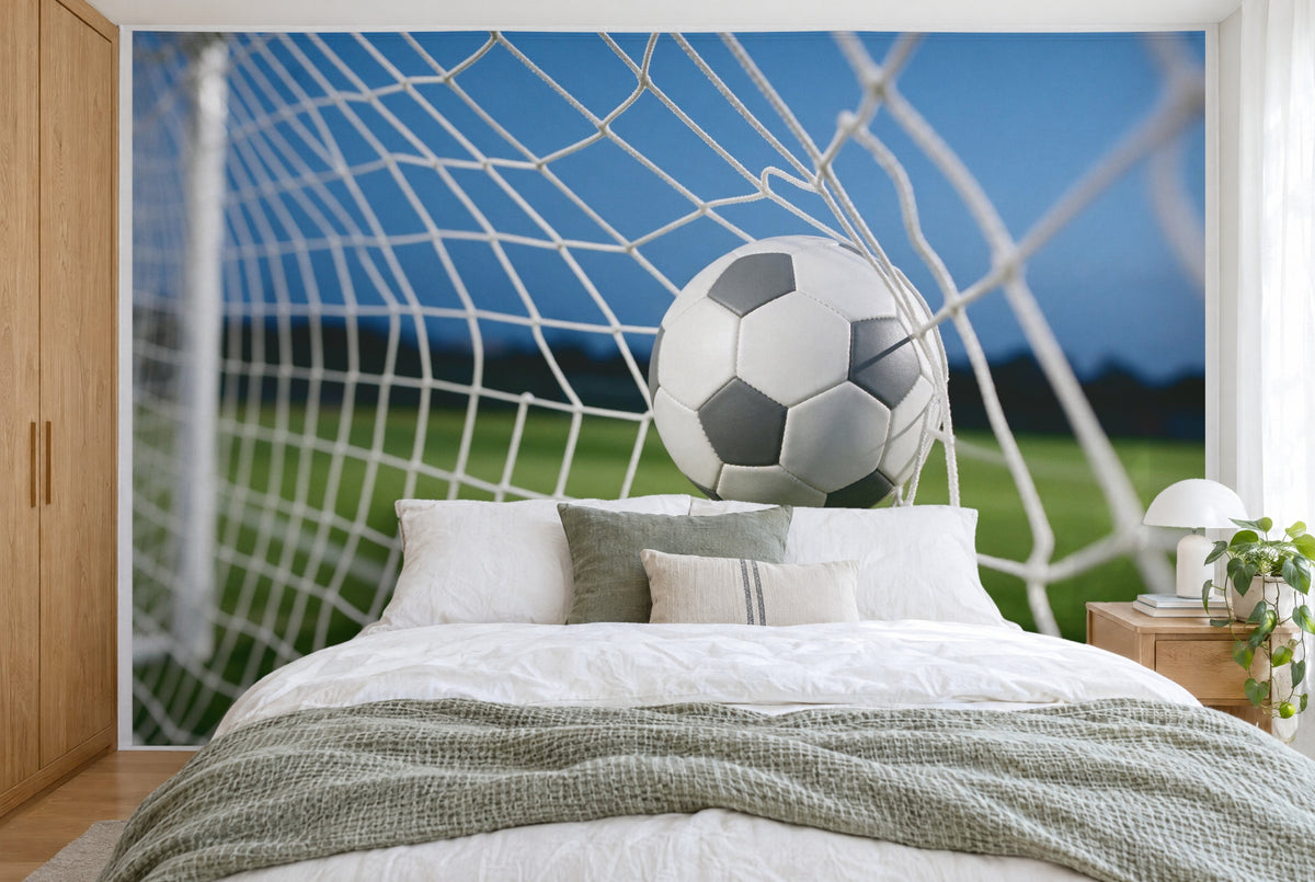 Bedruckter Stoff im XXL-Format: Fussball rechts der Mitte im ausgebeulten Tornetz vor Rasen, wandfüllend hinter dem Bett