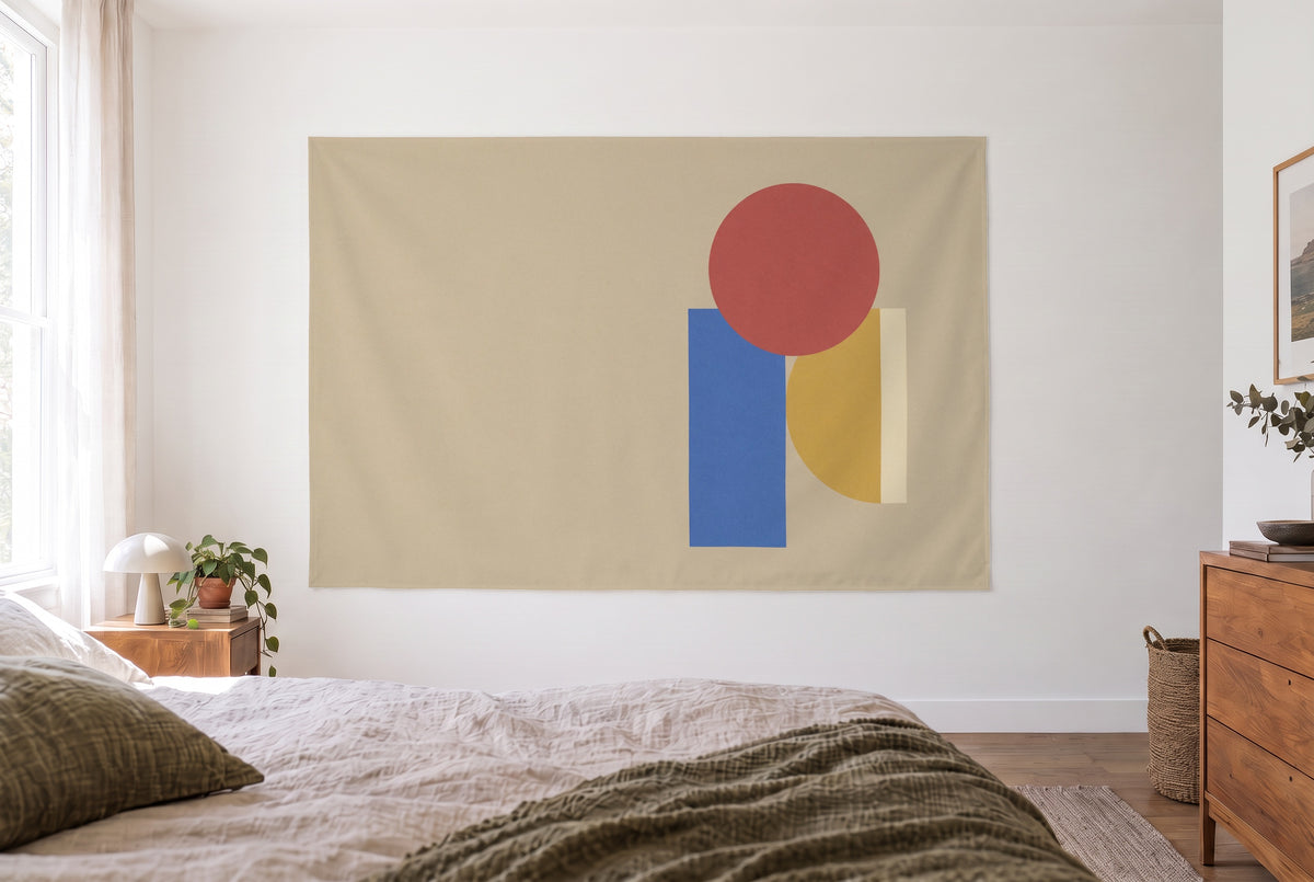Wandtuch Geometrische Grundformen in Rot, Gelb und Blau im hellen Schlafzimmer gegenüber dem Bett, rechts eine Holzkommode