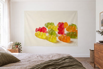 Wandtuch Bunte Gummibärchen im hellen Schlafzimmer gegenüber dem Bett, rechts eine Holzkommode – Rot, Gelb und Grün