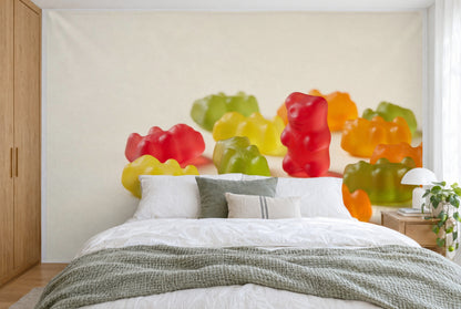 Bedruckter Stoff im XXL-Format: rotes Bärchen steht rechts zwischen bunten Gummibärchen, wandfüllend hinter dem Bett
