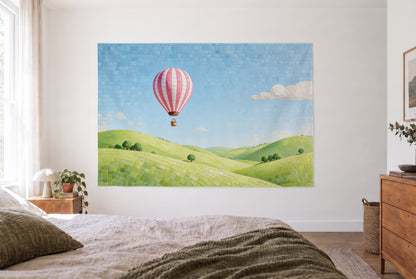 Tapiz Globo aerostático en mosaico en el dormitorio frente a la cama, cómoda de madera a la derecha – rosa, verde y azul