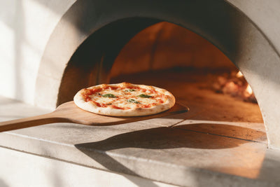 Pizza de horno de leña con albahaca en pala larga de madera ante el horno de piedra, tapiz impreso en tela – rojo y beige