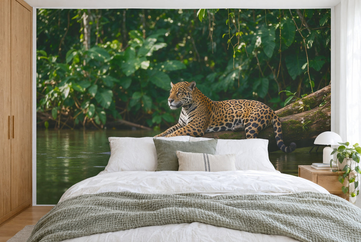 Tela impresa XXL: felino sobre un tronco a la derecha del centro, selva tropical y río, pared entera tras la cama