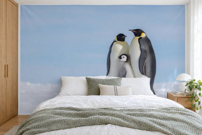Bedruckter Stoff im XXL-Format: Pinguin-Familie mit flauschigem Küken rechts vor Himmelblau, wandfüllend hinter dem Bett