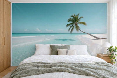 XXL printed fabric: slanted palm on the white beach at right, turquoise water at left, filling the wall behind the bed