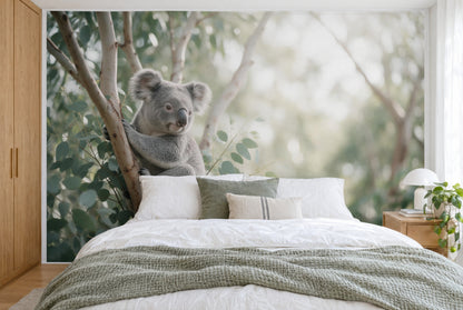 Tissu imprimé XXL : koala à gauche, branche d'eucalyptus claire, forêt verte floue à droite, mur entier derrière le lit