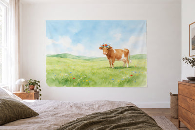 Wandtuch Kuh mit Blumenkranz auf der Wiese im hellen Schlafzimmer gegenüber dem Bett, rechts eine Holzkommode – Grün