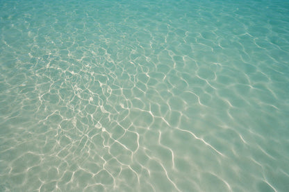 Türkises Wasser mit feinem Lichtnetz links über hellem Sandgrund, als Wandtuch, auf Stoff gedruckt – Blau, Grün und Beige