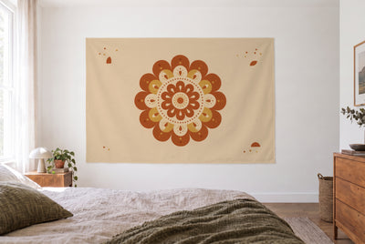 Tenture mandala bohème terracotta dans une chambre claire face au lit, une commode en bois à droite – orange et beige