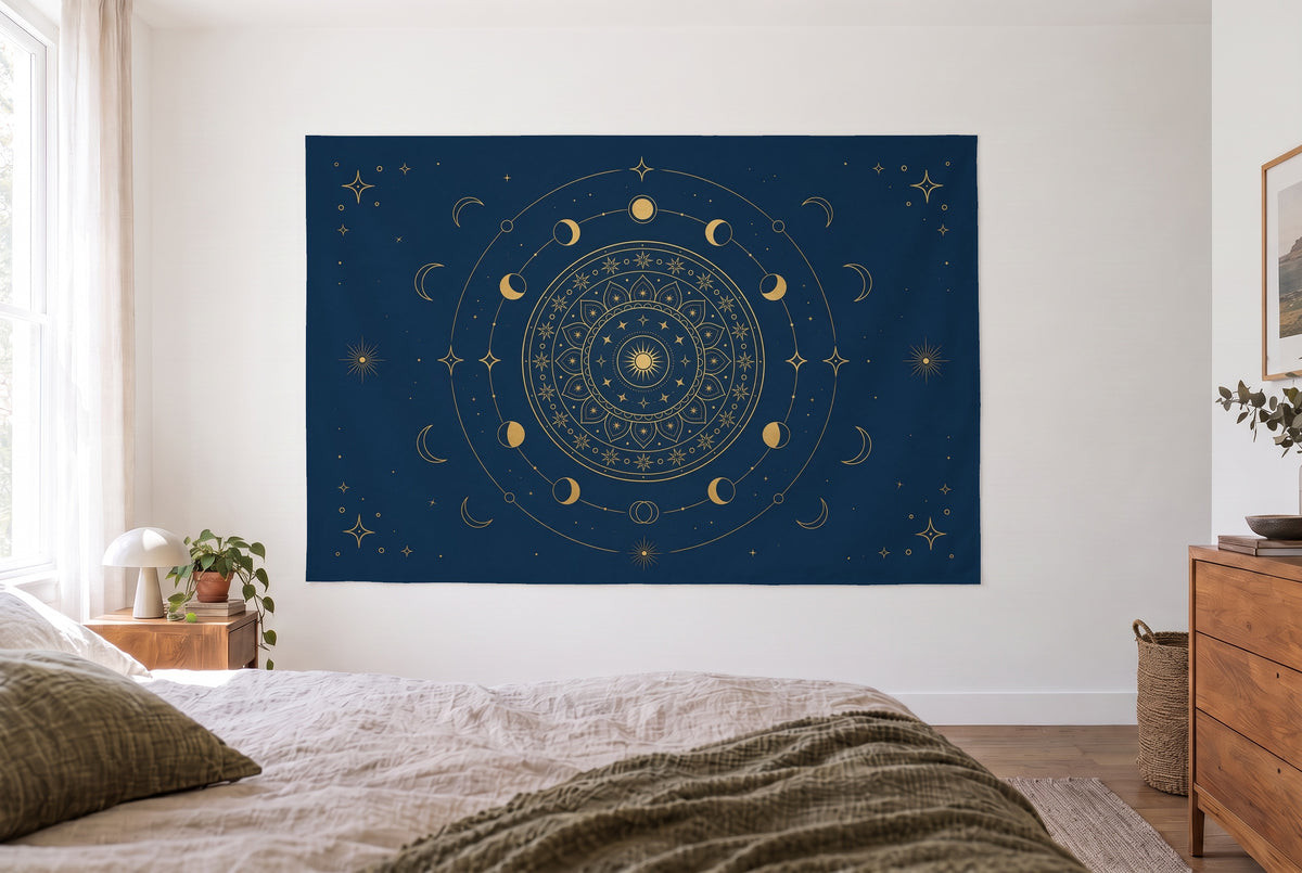 Tenture mandala soleil et lune bleu et or dans une chambre claire face au lit, une commode en bois à droite