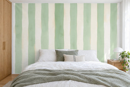 Tela impresa XXL: rayas pintadas en verde salvia y crema, una más ancha a la izquierda, cubriendo la pared tras la cama