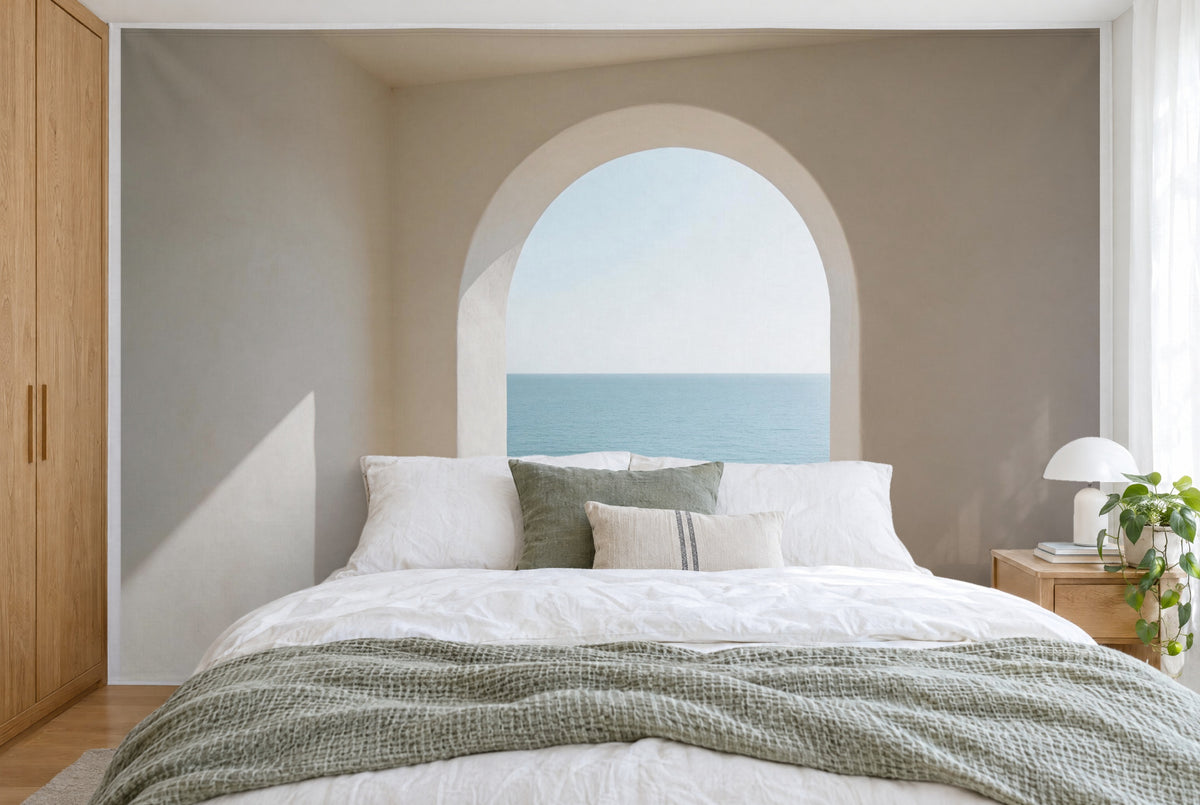 Bedruckter Stoff im XXL-Format: weisser Rundbogen mit Meerblick mittig, Sandbeige und Aquablau, wandfüllend hinter dem Bett