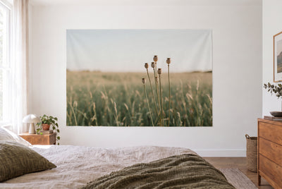 Tapiz cápsulas de amapola en la pradera en dormitorio claro frente a la cama, cómoda de madera a la derecha – marrón y dorado