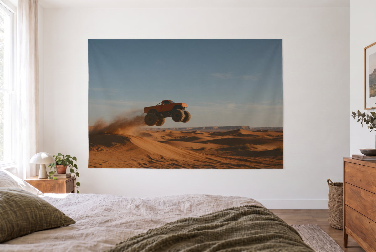 Monster Truck in the Desert tapestry in a bright bedroom opposite the bed, wooden dresser at right – orange and blue