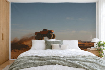 XXL printed fabric: monster truck mid-jump left of center, dunes and dust below, filling the wall behind the bed