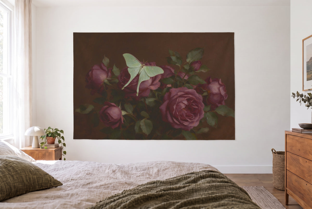 Moth on dark roses tapestry in a bright bedroom opposite the bed, a wooden chest of drawers on the right – green and plum