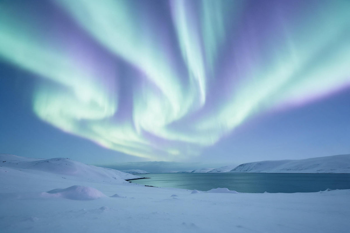 Nordlichter in Grün und Violett über Schneehügeln und Petrol-Fjord als Wandtuch, auf Stoff gedruckt – Blau und Violett