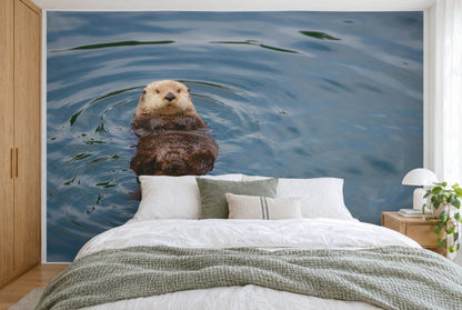 Bedruckter Stoff im XXL-Format: Otter links auf dem Rücken in ruhigem Wasser mit Wasserringen, wandfüllend hinter dem Bett