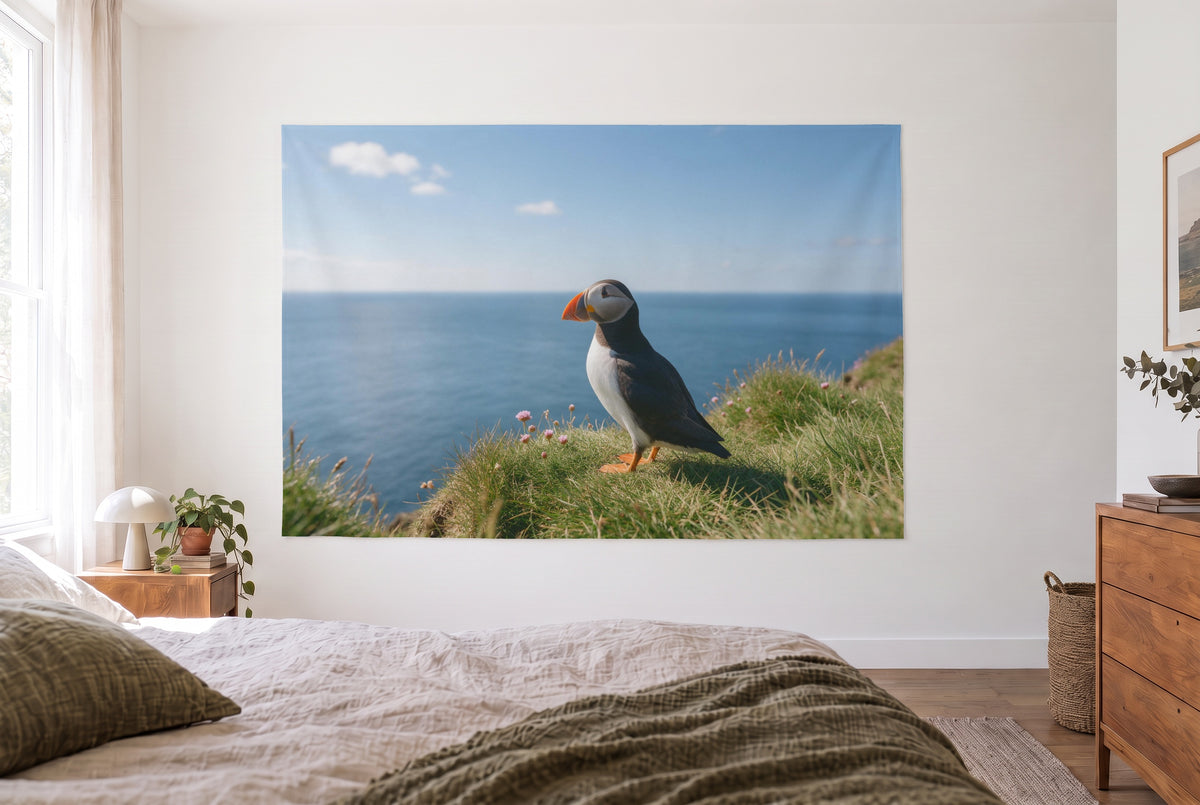 Puffin on the cliff tapestry in a bright bedroom opposite the bed, wooden dresser on the right – green and blue
