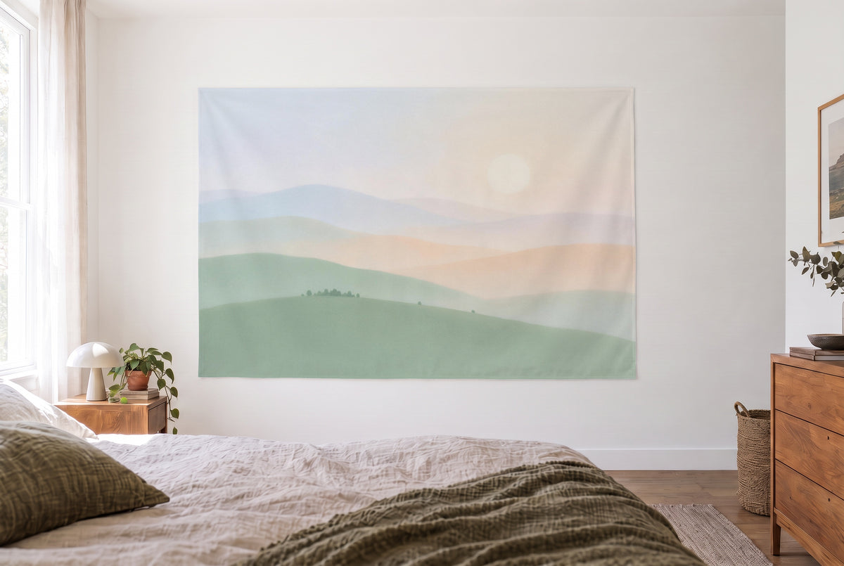 Wandtuch Pastell-Landschaft im hellen Schlafzimmer gegenüber dem Bett, rechts eine Holzkommode – Salbei und Nebelblau
