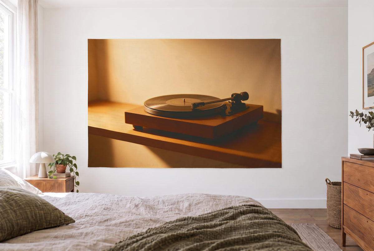 Wandtuch Plattenspieler mit Schallplatte im hellen Schlafzimmer gegenüber dem Bett, rechts eine Holzkommode – Braun und Gold