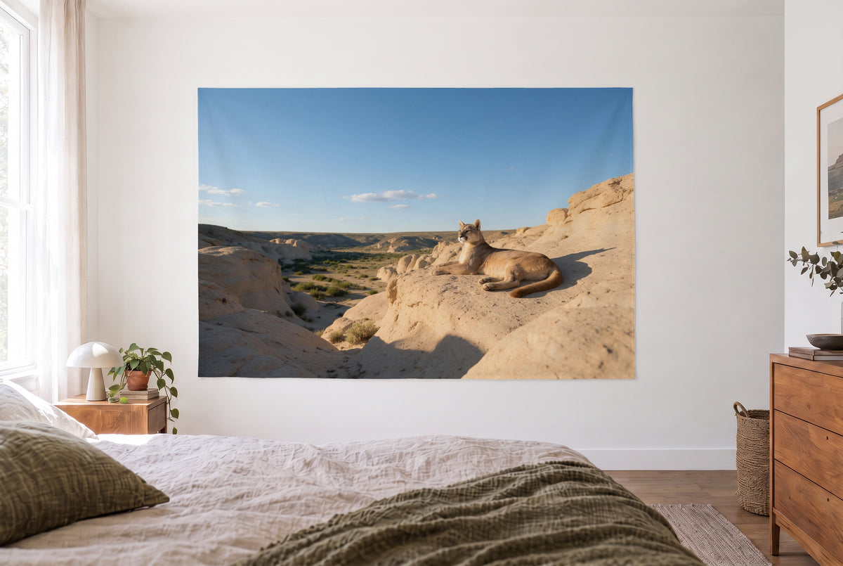 Wandtuch Puma auf dem Felsvorsprung im hellen Schlafzimmer gegenüber dem Bett, rechts eine Holzkommode – Beige und Blau