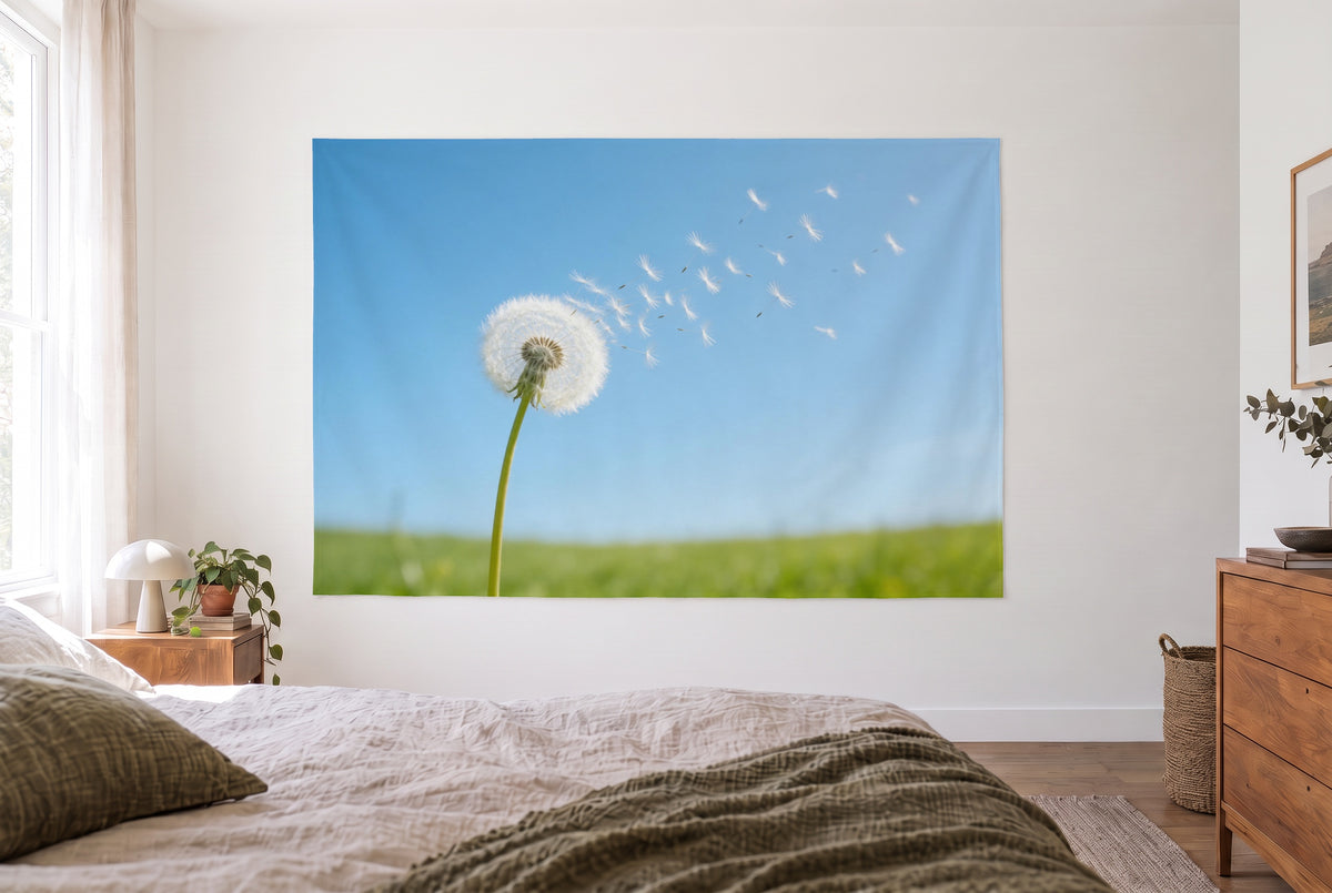 Wandtuch Pusteblume im Frühlingswind im hellen Schlafzimmer gegenüber dem Bett, rechts eine Holzkommode – Blau und Grün