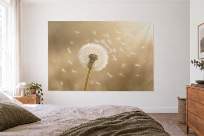 Tenture murale Pissenlit en contre-jour doré dans la chambre claire face au lit, commode en bois à droite – beige doré