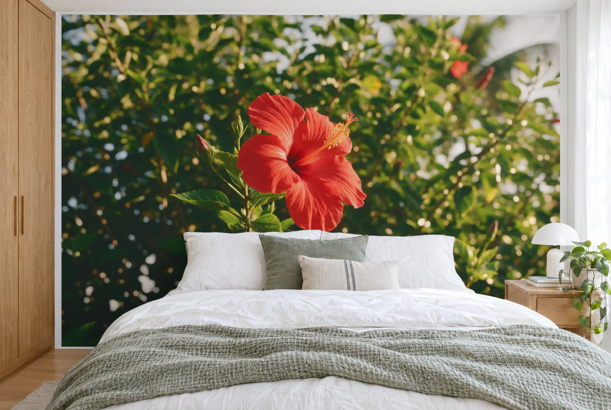 Tela impresa XXL: flor de hibisco roja con capullos a la izquierda ante verdor tropical, pared entera tras la cama