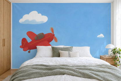 XXL printed fabric: red plane at left below a cloud, open sky at right, filling the wall behind the bed