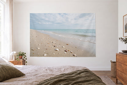 Wandtuch Sandstrand mit Muscheln unter Wolkenhimmel im hellen Schlafzimmer gegenüber dem Bett, rechts eine Holzkommode