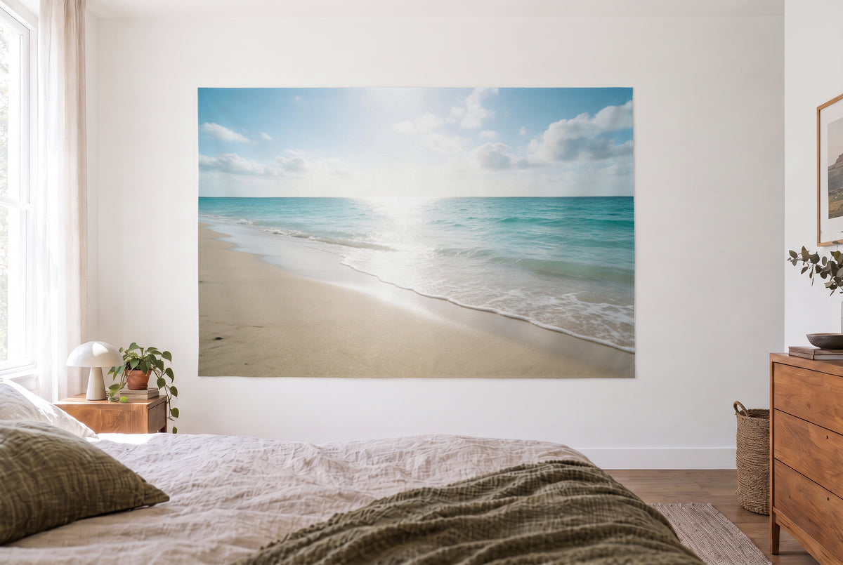 Tenture murale plage mer turquoise dans la chambre claire face au lit, commode en bois à droite – turquoise et beige