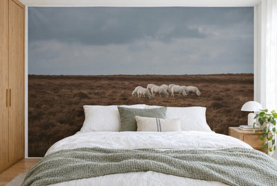 Bedruckter Stoff im XXL-Format: Schafherde rechts der Mitte auf brauner Heide unter Wolken, wandfüllend hinter dem Bett