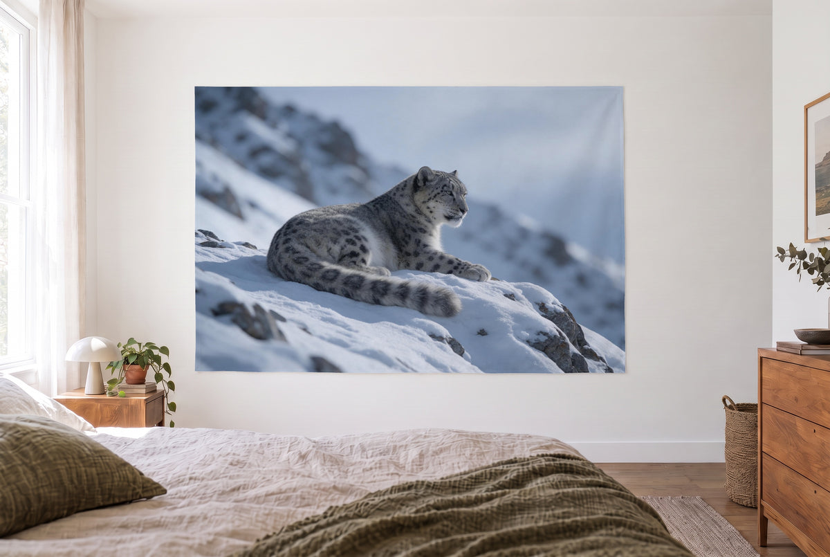 Tapiz leopardo de las nieves sobre una roca en un dormitorio claro frente a la cama, una cómoda a la derecha – gris