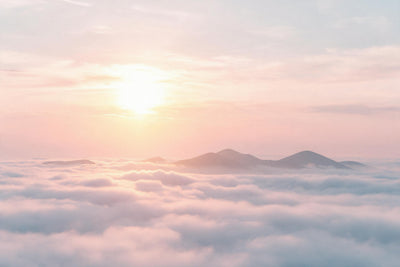 Rising sun over the sea of clouds with soft mountain tops and golden sun, tapestry printed on fabric – pink and gold