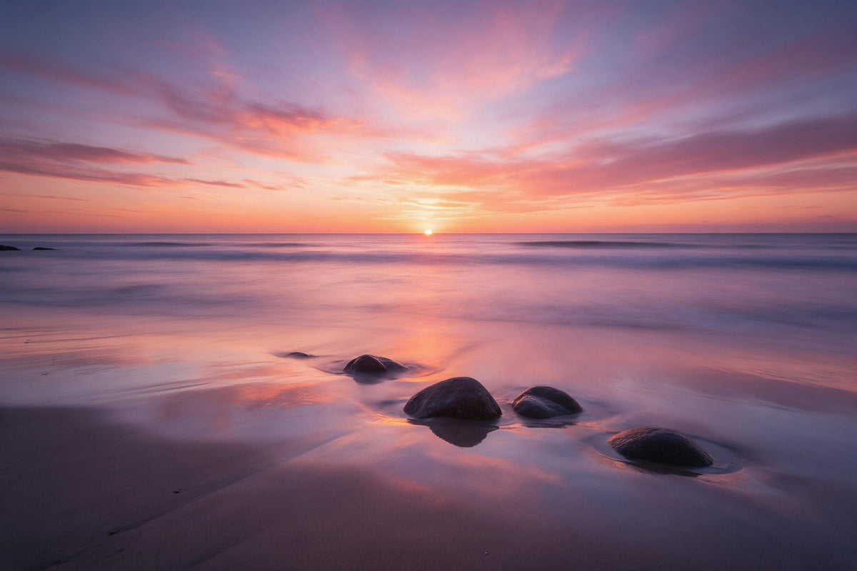 Sonnenuntergang am Meer mit dunklen Felsen am nassen Strand, als Wandtuch, auf Stoff gedruckt – Orange und Rosa