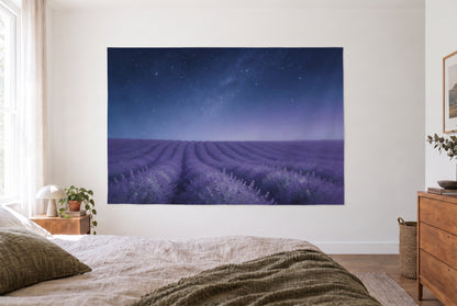 Wandtuch Sternenhimmel über Lavendelfeld im hellen Schlafzimmer gegenüber dem Bett, rechts Holzkommode – Blau und Violett