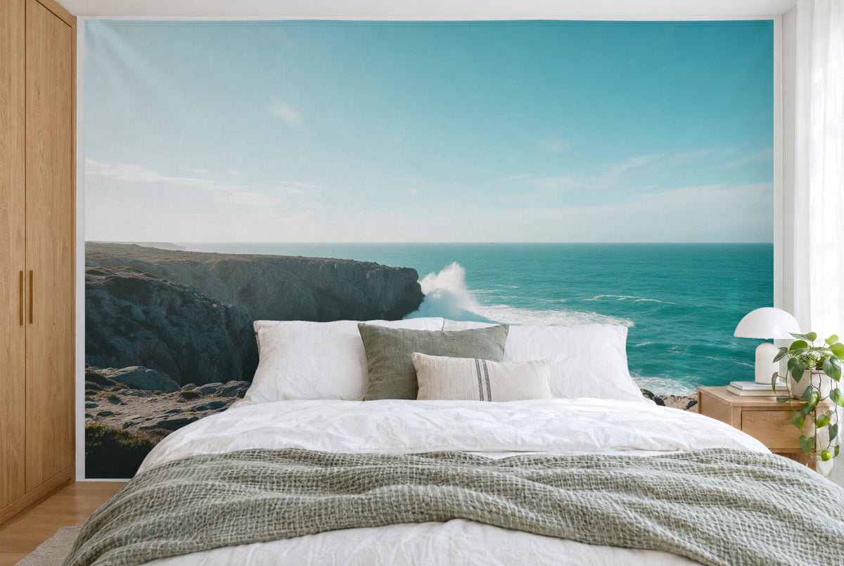Bedruckter Stoff im XXL-Format: Brandung an Felsen und türkises Meer, wandfüllend hinter dem Bett