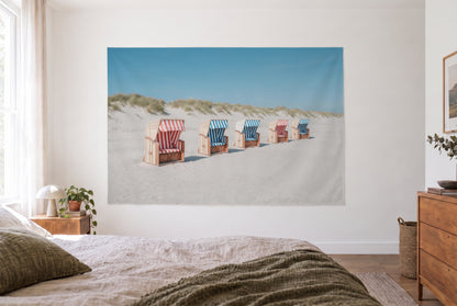 Wandtuch Strandkorb-Idylle am Dünenstrand im hellen Schlafzimmer gegenüber dem Bett, rechts eine Holzkommode – Blau und Rot