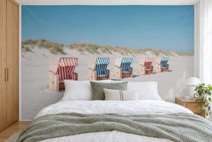Bedruckter Stoff im XXL-Format: fünf gestreifte Strandkörbe in schräger Reihe vor Dünen, wandfüllend hinter dem Bett