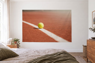 Tenture murale Balle de tennis sur terre battue dans la chambre claire face au lit, commode bois à droite – rouge et jaune