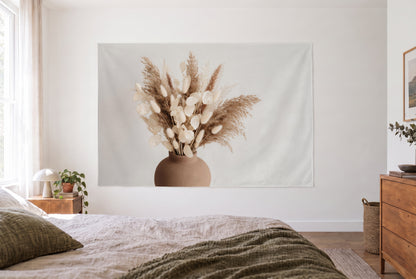 Wandtuch Trockenblumen in der Tonvase im hellen Schlafzimmer gegenüber dem Bett, rechts eine Holzkommode – Beige Braun