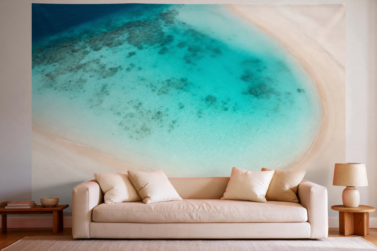 Tapiz de pared XXL Playa tropical desde arriba con agua turquesa como decoración en un salón luminoso sobre el sofá