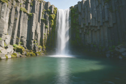 Cascada entre columnas de basalto grises con musgo sobre una poza turquesa, tapiz impreso en tela – gris y verde