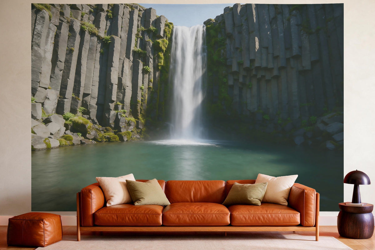 Tapiz de pared XXL Cascada sobre rocas de basalto como decoración en un salón acogedor sobre el sofá de cuero