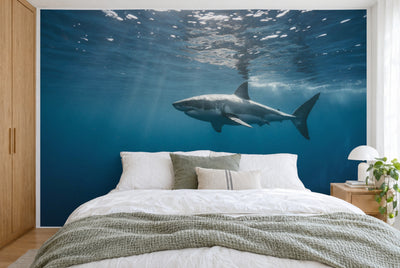 XXL printed fabric: great white shark right of center in deep ocean blue, filling the wall behind the bed