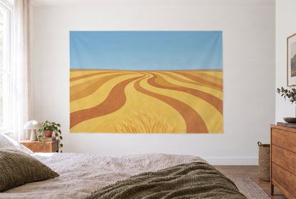 Wandtuch Weizenfeld abstrakt im hellen Schlafzimmer gegenüber dem Bett, rechts eine Holzkommode – Gold und Blau