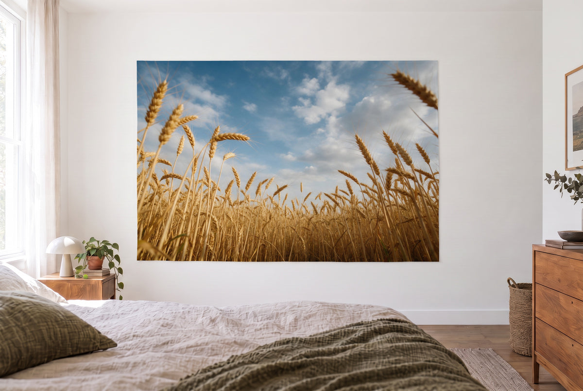 Wandtuch Weizenfeld unter Wolkenhimmel im hellen Schlafzimmer gegenüber dem Bett, rechts eine Holzkommode – Gold und Blau